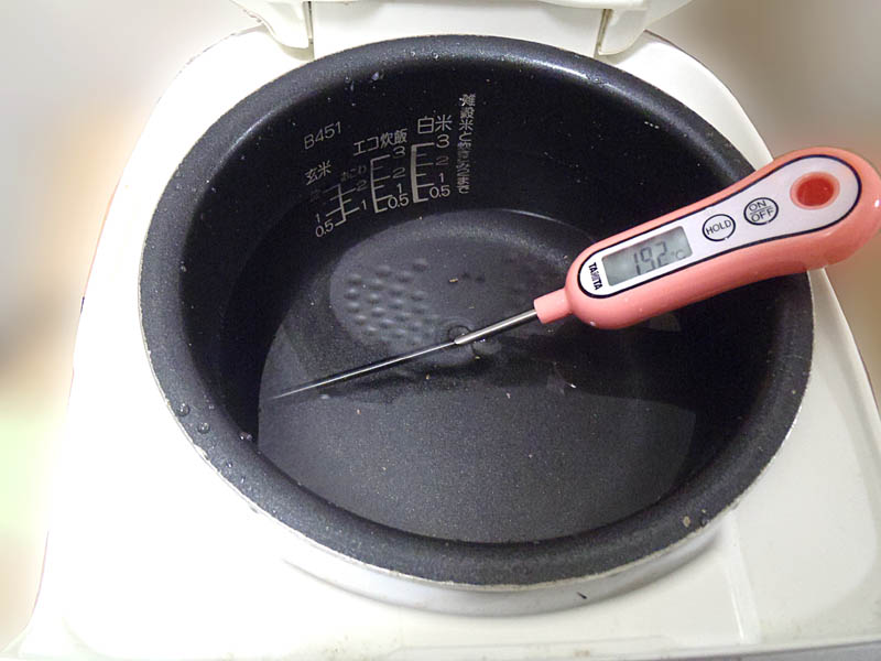 炊飯器の釜にデジタル温度計を入れて温度を測っている